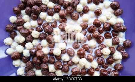Healthy breakfast with milk on the table in a deep plate. Whole grain chocolate and milk balls. Healthy cereal breakfast. Children's breakfast. Baby Stock Photo