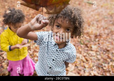 Portrait playful boy holding autumn leaf Stock Photo