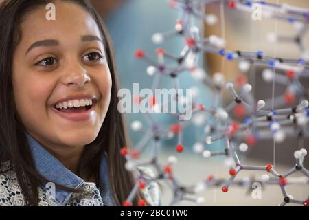 Curious, smiling girl student examining molecular structure Stock Photo