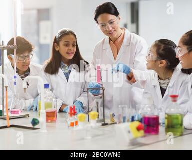 Female teacher and students conducting scientific experiment in laboratory classroom Stock Photo