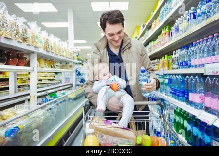 Father with baby daughter shopping in supermarket Stock Photo