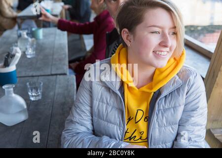 Smiling young woman dining at restaurant outdoor patio Stock Photo