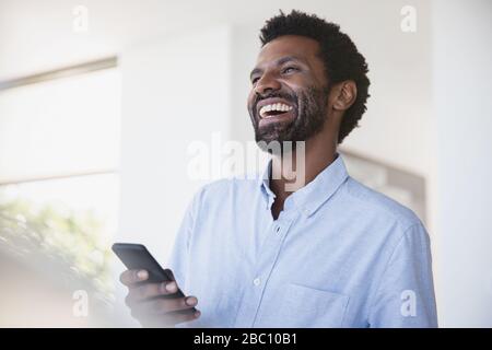 Laughing man using cell phone Stock Photo