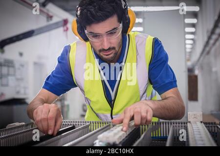 Male engineer assembling equipment in factory Stock Photo