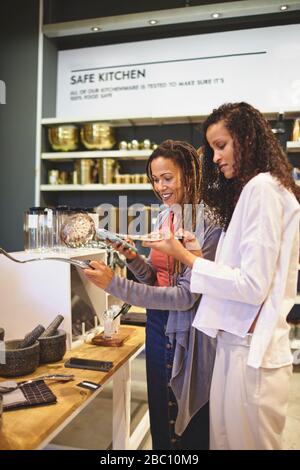 Women with smart phone shopping in home goods store Stock Photo