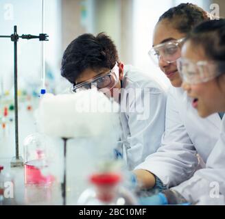 Students watching chemical reaction, conducting scientific experiment in laboratory classroom Stock Photo