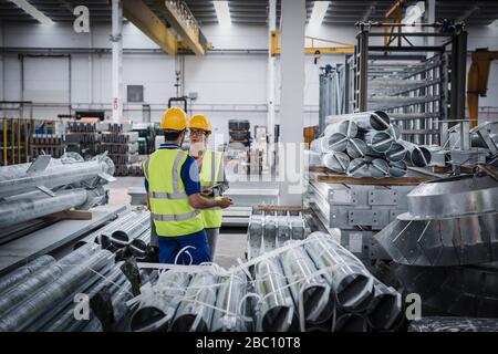 Workers talking in steel factory Stock Photo