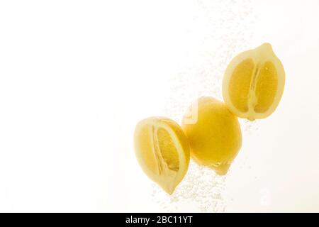 Lemons in water splash. Tasty and healthy summer food on white background. Stock Photo