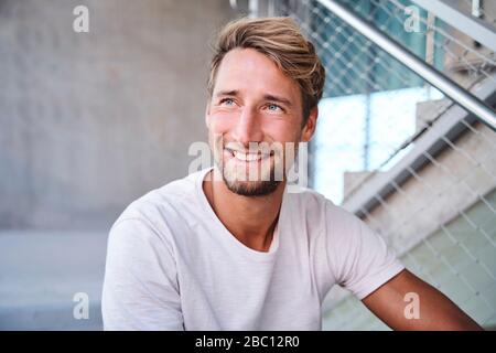 Portrait of smiling young man wearing white t-shirt Stock Photo
