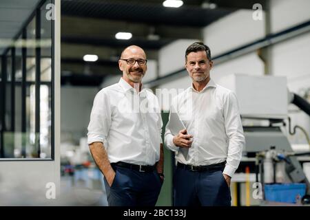 Portrait of two confident businessmen in a factory Stock Photo