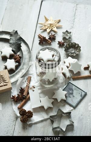 Star shaped cookies, cinnamon sticks, old photograph, pine cones, cookie cutter, star anise, glass jar and Christmas decorations