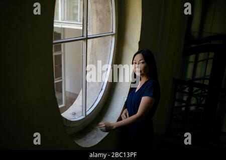 Portrait of woman standing beside window Stock Photo
