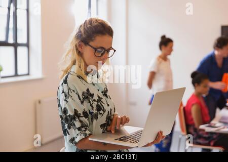 Focused businesswoman using laptop in conference room Stock Photo