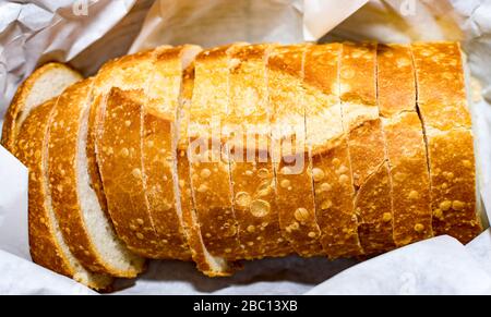 Deliciously looking golden bread wrapped on paper close up shot. Good for bakeshop or pastry shop business Stock Photo