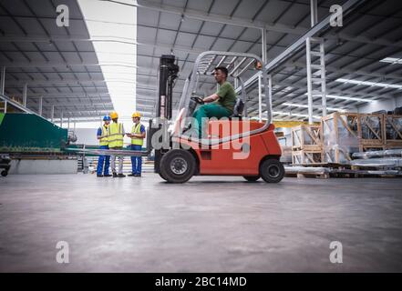 Male worker driving forklift in factory Stock Photo