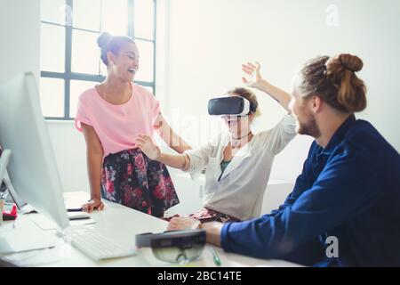 Computer programmers testing virtual reality simulator glasses at computer in office Stock Photo