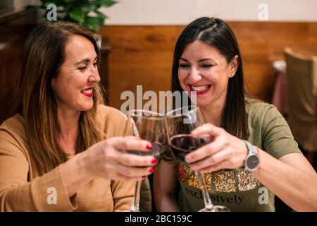 Friends toasting with glasses of red wine in a restaurant Stock Photo