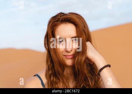 Portrait of smiling redheaded young woman in Sahara Desert, Merzouga, Morocco Stock Photo