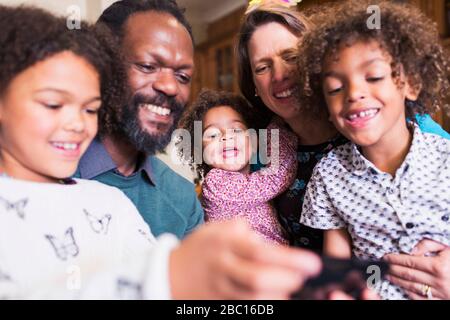 Happy multiethnic family using smart phone Stock Photo