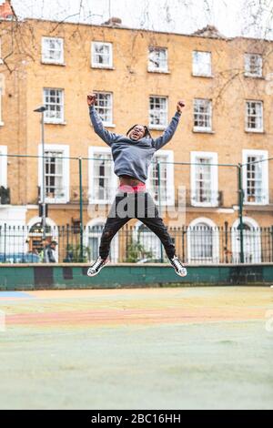 Young happy man jumping and laughing in the city Stock Photo
