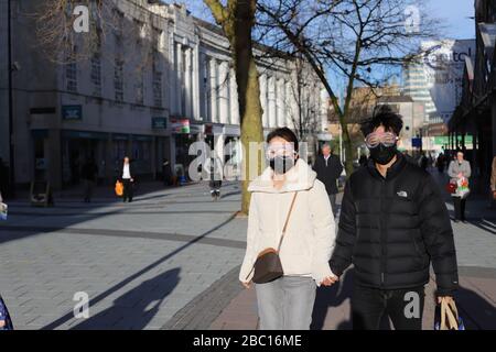 Cardiff UK. 17 March. A young couple wear a face mask and goggles in the streets of Cardiff due to the ongoing coronavirus situation.(Steffan Clifton) Stock Photo