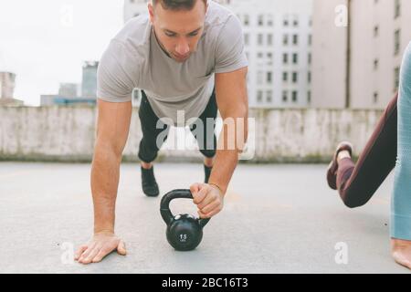Man and woman doing push ups in the city, Vancouver, Canada Stock Photo