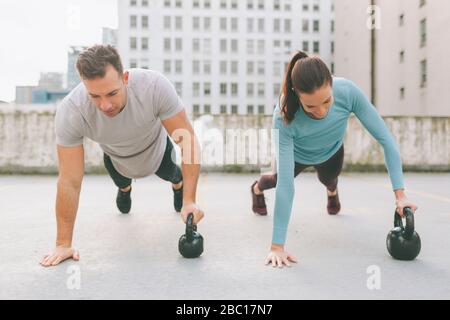 Man and woman doing push ups in the city, Vancouver, Canada Stock Photo