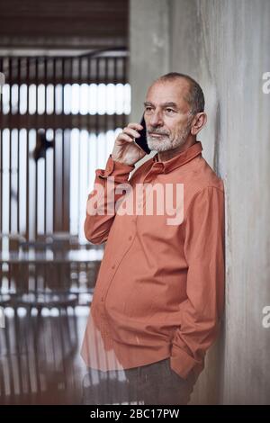 Creative businessman talking on the phone in his minimalistic office Stock Photo