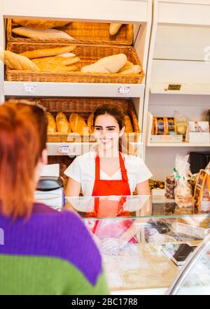 Young woman serving female customer in a bakery Stock Photo