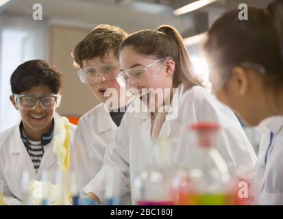 Surprised students conducting exploding foam scientific experiment in classroom laboratory Stock Photo