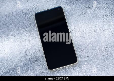 Mobile smart phone on grunge gray background. Copy space. Place for text Stock Photo