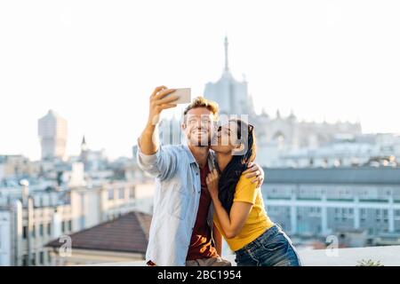 Happy young couple taking a selfie above the city, Milan, Italy Stock Photo
