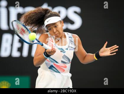 Japanese tennis player Naomi Osaka playing a high forehand shot in Australian Open 2020 tennis tournament, Melbourne Park, Melbourne, Victoria, Austra Stock Photo