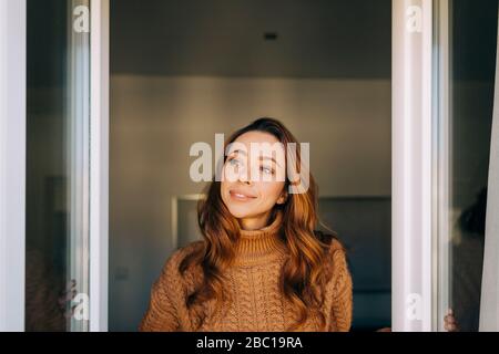 Portrait of young woman at the window Stock Photo