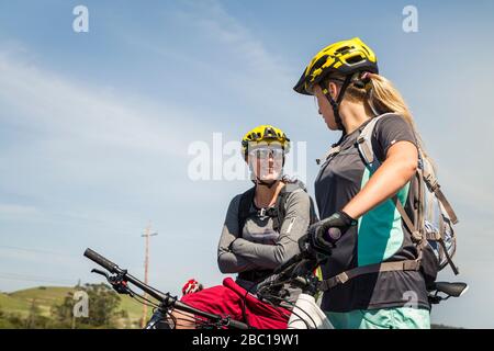 Two women on mountain bikes having a break Stock Photo