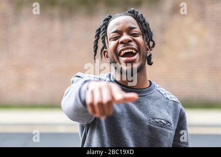 Laughing young man, pointing at camera Stock Photo
