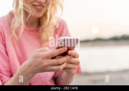 Close-up of young woman using smartphone outdoors Stock Photo