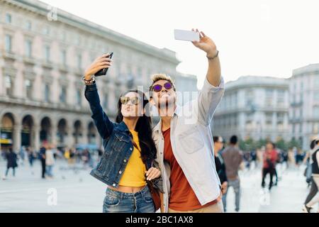 Happy young couple taking selfies in the city, Milan, Italy Stock Photo
