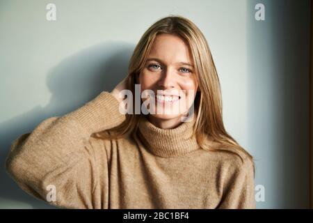 Portrait of smiling blond young woman Stock Photo