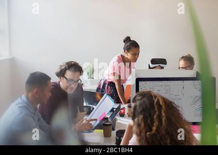 Computer programmers and designers working in open plan office Stock Photo