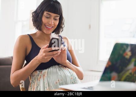 Happy pregnant woman using smart phone Stock Photo