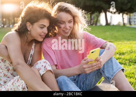 Two young women using smartphone Stock Photo - Alamy