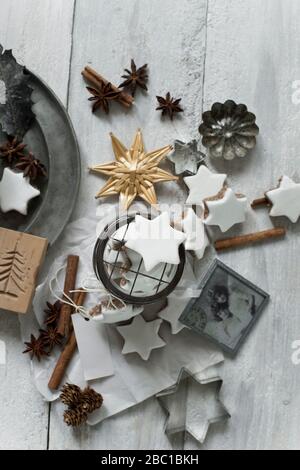 Star shaped cookies, cinnamon sticks, old photograph, pine cones, cookie cutters, star anise, glass jar and Christmas decorations