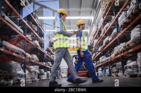 Workers with clipboard walking in warehouse Stock Photo