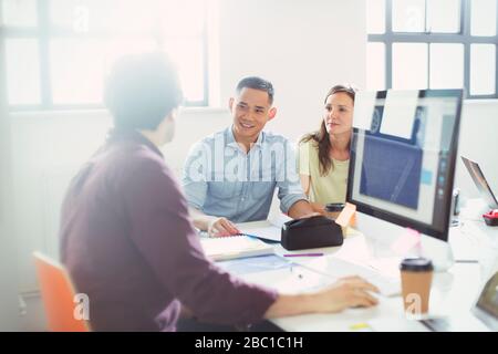 Designers talking, working at computer in office Stock Photo