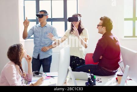 Computer programmers testing virtual reality simulator glasses in office Stock Photo