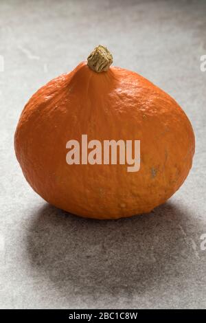 Fresh orange Hokkaido pumpkin close up on a wooden background Stock Photo