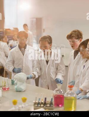 Surprised students conducting exploding foam scientific experiment in classroom laboratory Stock Photo