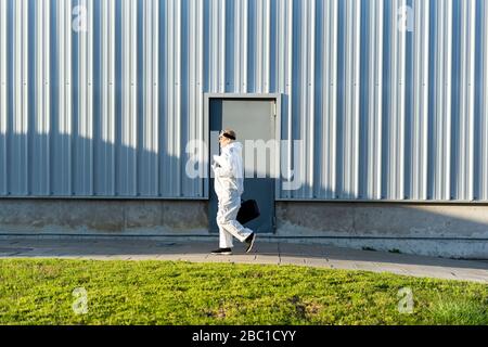 Female scientist wearing protective suit in front of a laboratory Stock Photo