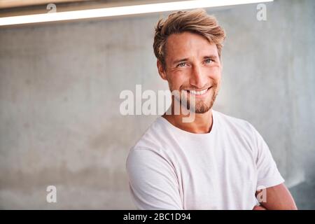 Portrait of smiling young man wearing white t-shirt Stock Photo